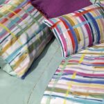 Pennellate colorate in un accattivante intreccio tingono la collezione Fili che prende il nome proprio dall’idea della trama e dell’ordito espressa dal disegno. La parte superiore delle federe è in percalle di puro cotone stampato in digitale; tutto il resto del completo è in percalle tinta unita; la balza del lenzuolo è impreziosita da cordonetto ricamato multicolor. 1 piazza: sopra 160×295 cm – sotto 90x200x30 cm – federa 52×82 cm 1 piazza e mezza: sopra 260x295 cm - sotto 140x200x30 cm - federe 52x82 cm