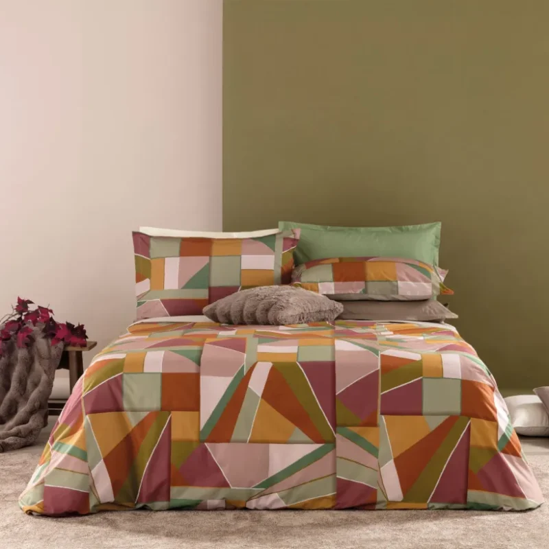 L’eleganza naturale prende forma in ogni piega della parure copripiumino Brody, ispirata ad uno stile geometrico senza tempo. Realizzata in percalle di puro cotone 100%, questo set di biancheria da letto combina la delicatezza del tessuto con una stampa digitale ad alta definizione che cattura ogni sfumatura. Il sacco copripiumino misura 250×200 + 40 cm La confezione include 2 federe piazzate da 50×80 cm, arricchite da quattro volant per un tocco raffinato e sartoriale. C'è la versione in Rosa loto con colori sul rosa, beige e fuxia, Il verde petrolio con colori sul verde-beige-petrolio.