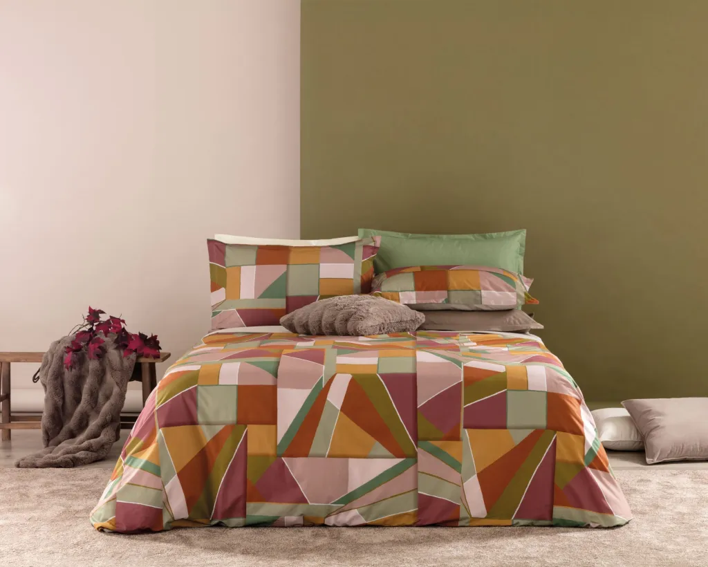 L’eleganza naturale prende forma in ogni piega della parure copripiumino Brody, ispirata ad uno stile geometrico senza tempo. Realizzata in percalle di puro cotone 100%, questo set di biancheria da letto combina la delicatezza del tessuto con una stampa digitale ad alta definizione che cattura ogni sfumatura. Il sacco copripiumino misura 250×200 + 40 cm La confezione include 2 federe piazzate da 50×80 cm, arricchite da quattro volant per un tocco raffinato e sartoriale. C'è la versione in Rosa loto con colori sul rosa, beige e fuxia, Il verde petrolio con colori sul verde-beige-petrolio.