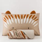 Parure Copripiumino Cotone Ciuffi Un riccio sorridente accoglie il sonno dei più piccoli con dolcezza, trasformando il letto in un rifugio tenero e rassicurante. La parure copripiumino Ciuffi porta nella cameretta dei bambini un piccolo amico immaginario, pronto a vegliare sui sogni con il suo musetto buffo e i ciuffi di colore che si rincorrono come pennellate leggere. Realizzata in percalle 100% cotone stampato, la parure avvolge con naturalezza e traspirabilità ed è ideale per accompagnare il riposo in ogni stagione. Il set è composto dal sacco copripiumino e una federa da 50x80 cm, proposto sia nella versione singola (155x200 + 40 cm)  La palette nei toni tortora, terra e arancio bruciato scalda l’ambiente senza appesantirlo, creando un equilibrio visivo che stimola la fantasia senza rinunciare alla sensazione di calma che deve accompagnare il momento della nanna. Perfetta per chi desidera uno stile tenero ma moderno, capace di far sorridere grandi e piccoli. Il set è composto dal sacco copripiumino  cm 155x200 + 40 cm e una federa da 50x80 Qualità/Materiali: 100% Percalle di Cotone Dimensione Singolo: cm 155X200 + cm 40 pattella Federe: 1 federa cm 50x80 Certificazione: OEKO TEX