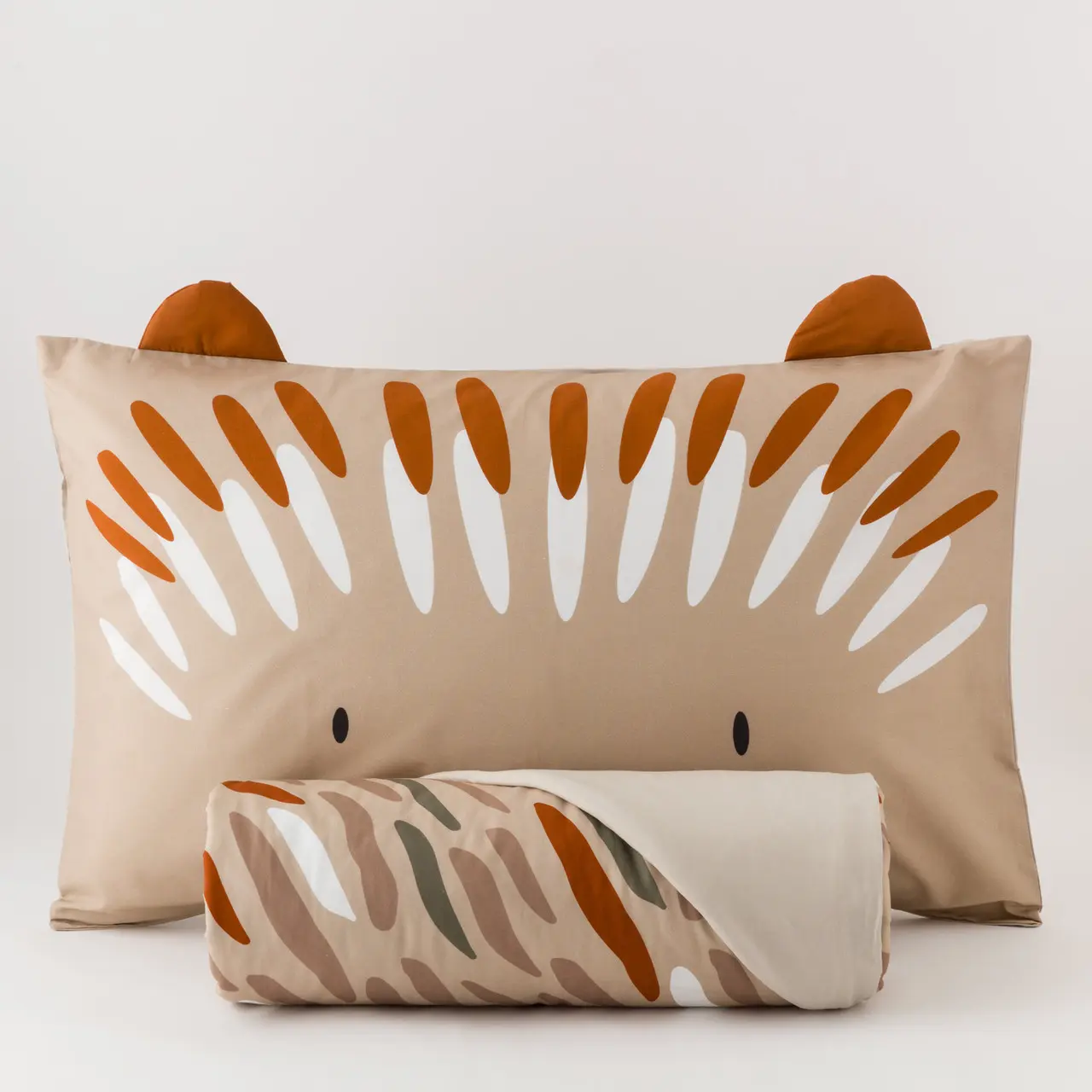 Parure Copripiumino Cotone Ciuffi Un riccio sorridente accoglie il sonno dei più piccoli con dolcezza, trasformando il letto in un rifugio tenero e rassicurante. La parure copripiumino Ciuffi porta nella cameretta dei bambini un piccolo amico immaginario, pronto a vegliare sui sogni con il suo musetto buffo e i ciuffi di colore che si rincorrono come pennellate leggere. Realizzata in percalle 100% cotone stampato, la parure avvolge con naturalezza e traspirabilità ed è ideale per accompagnare il riposo in ogni stagione. Il set è composto dal sacco copripiumino e una federa da 50x80 cm, proposto sia nella versione singola (155x200 + 40 cm)  La palette nei toni tortora, terra e arancio bruciato scalda l’ambiente senza appesantirlo, creando un equilibrio visivo che stimola la fantasia senza rinunciare alla sensazione di calma che deve accompagnare il momento della nanna. Perfetta per chi desidera uno stile tenero ma moderno, capace di far sorridere grandi e piccoli. Il set è composto dal sacco copripiumino  cm 155x200 + 40 cm e una federa da 50x80 Qualità/Materiali: 100% Percalle di Cotone Dimensione Singolo: cm 155X200 + cm 40 pattella Federe: 1 federa cm 50x80 Certificazione: OEKO TEX