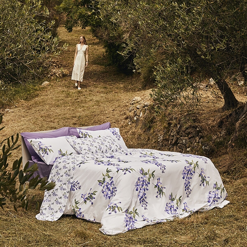 Il fiore del GLICINE, simbolo di equilibrio e armonia, decora l’omonima collezione, proposta più classica della stagione. È un disegno senza tempo che trova nuova vita attraverso giochi di proporzioni e raffinati contrasti tra fondo e motivo floreale. Preziosa stampa digitale - Percalle di puro cotoneIl completo gioca sull'abbinamento della stampa in versione micro e macro. Il copripiumino e le federe sono reversibili  sono in percalle di puro cotone stampato in digitale.  Misure: 2 piazze: sacco 250x260 cm - federe 52x82 cm NELLA STESSA VERSIONE DISPONIBILE IL LENZUOLO COPRILETTO